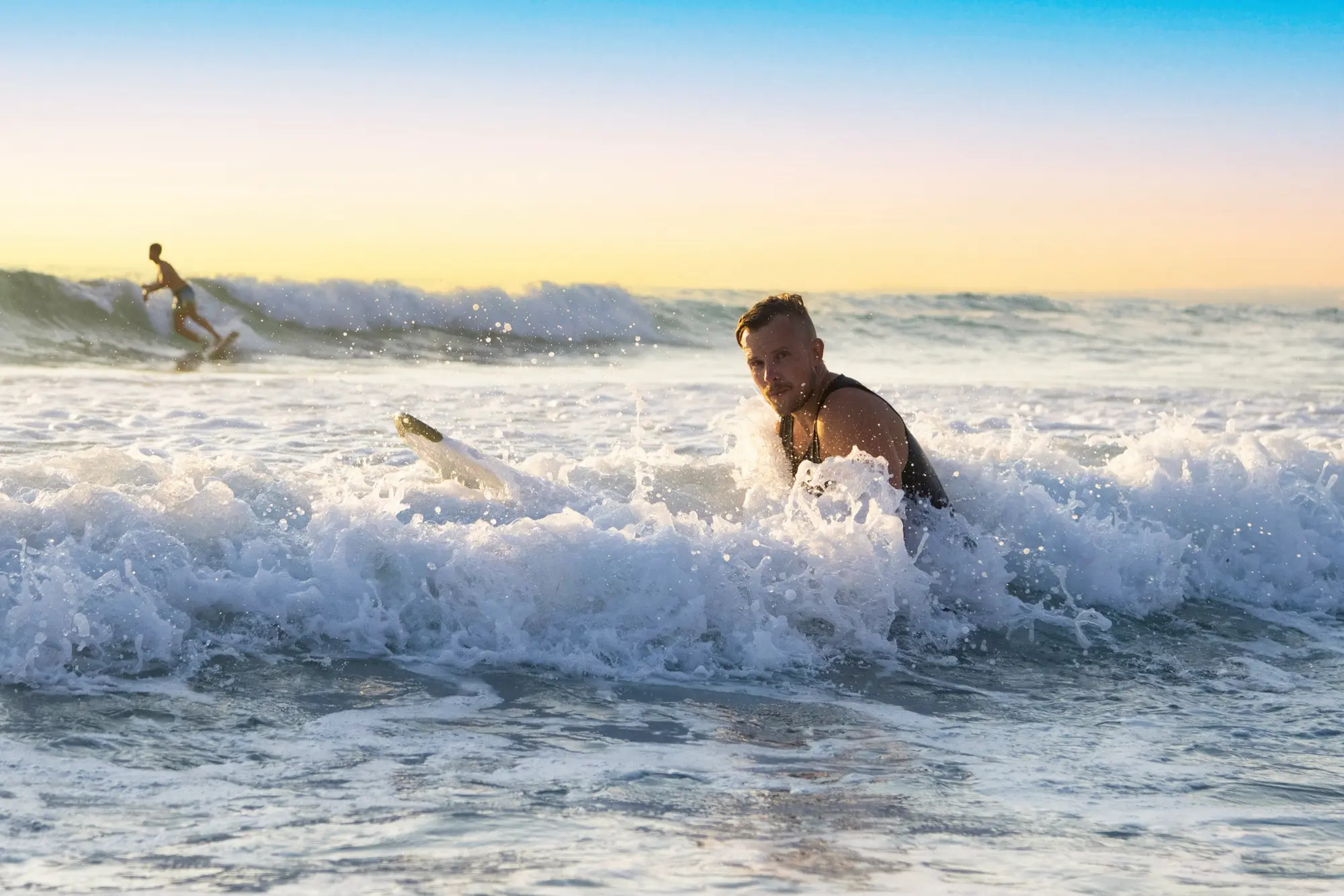 John Talasi catching waves at sunset
